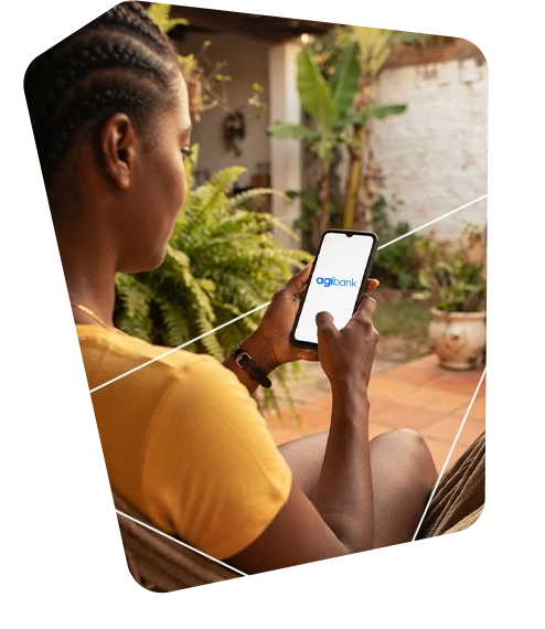 Consultor do Agibank, vestindo camiseta e boné azuis com o logo da empresa, mostra informações em um tablet para uma mulher idosa sorridente, em ambiente externo durante o dia.